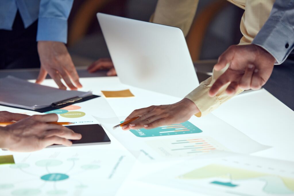 Team members’ hands examining data at Opal Core Marketing
